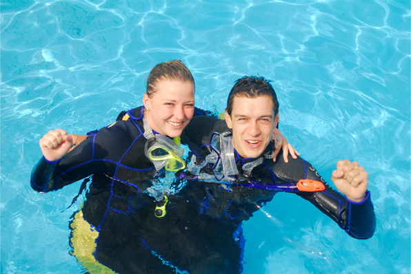 photo of young couple with dive gear on in pool